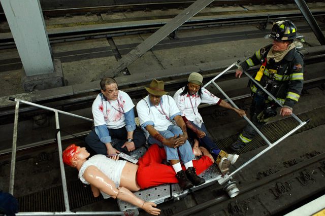During the emergency response drill, firefighters take "victims" of the simulated explosion away by aluminum rail cars.